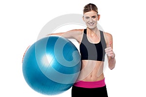 Fitness girl with aerobic ball showing thumbs sign