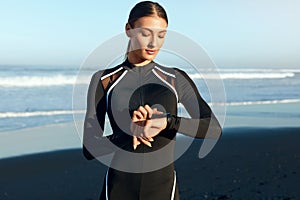 Fitness Girl Checks Workout Progress On Wrist Tracker. Sexy Woman In Sportswear Monitoring Information On Smart Watch.