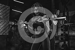 Fitness girl exercising with barbell in gym