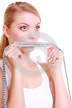 Fitness girl fit woman covering her mouth with measuring tape