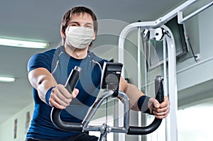 Fitness girl in gym in medical mask