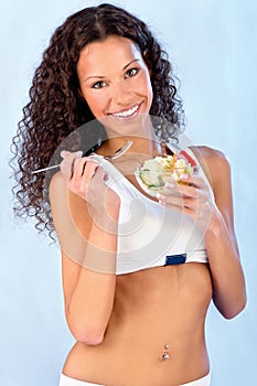 Fitness girl holding plate with salad