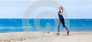 Fitness girl jogging at ocean beach on sunny day