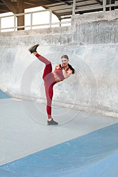 Fitness Girl Kicking. Full-Length Portrait Of Sexy Woman With Strong Muscular Body Working Out.