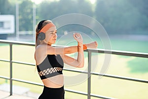 Fitness girl in leggings and tops is playing sports in the background of a city landscape, warmed up before training