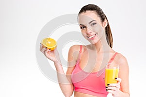 Fitness girl with orange half and glass of juice