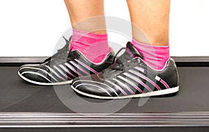 Fitness girl running on treadmill. Woman with muscular legs on w