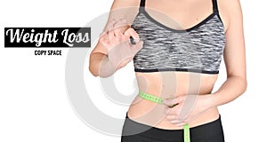 Fitness girl in sports tops measuring ruler waist on white background. The concept of losing weight