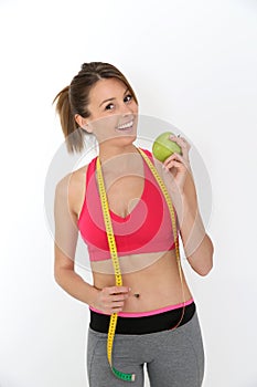 Fitness girl succeeding diet holding green apple, isolated