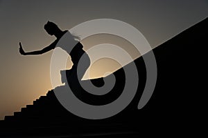 Fitness girl training on sunset, beautiful woman doing sports, silhouette of a girl is engaged in martial arts at sunset