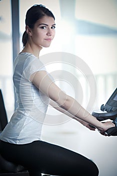 Fitness girl is working out with stepper.Strong brunette with curly hair doing aerobics on stepper