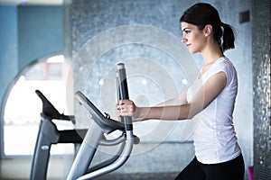 Fitness girl is working out with stepper.Strong brunette with curly hair doing aerobics on stepper