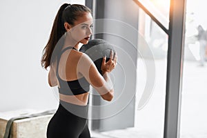 Fitness girl working out at white gym using ball