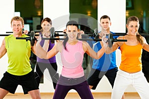 Fitness group with barbell in gym