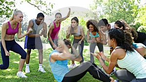 Fitness group cheering on man doing sit ups