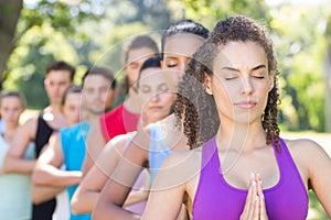 Fitness group doing yoga in park