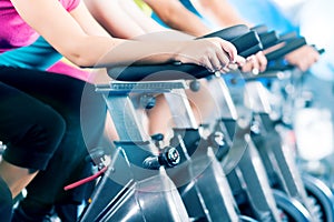 Fitness group Indoor bicycle cycling in gym