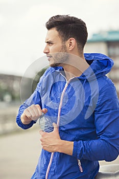 Fitness guy taking a break in between outdoors workouts