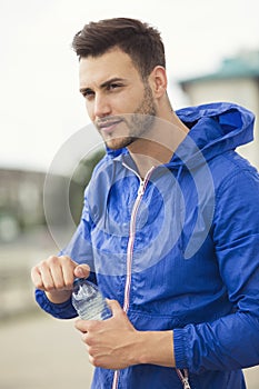 Fitness guy taking a break in between outdoors workouts