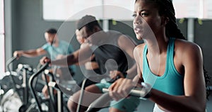 Fitness, gym or black woman on cycling machine for a biking workout or cardio training for endurance. Cyclist, exercise