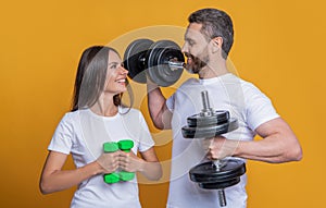 Fitness gym. Couple of strong sporty sportswoman and sportsman. Woman man do sport training exercise isolated on yellow