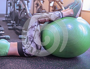 Fitness gym girl goes in for sports with a green ball.