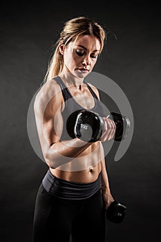 Fitness in gym, sport and healthy lifestyle concept. Beautiful athletic woman showing her trained body on black