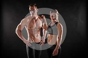 Fitness in gym, sport and healthy lifestyle concept. Couple of athletic man and woman showing their trained bodies on photo