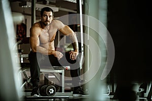 Fitness in gym, sport and healthy lifestyle concept. Handsome athletic man with naked torso making exercises