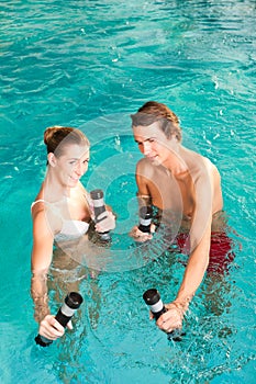 Fitness - gymnastics under water in swimming pool