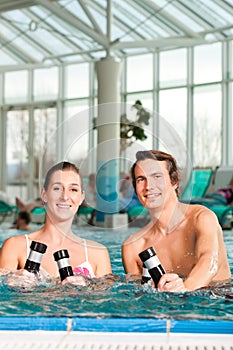 Fitness - gymnastics under water in swimming pool