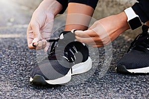 Fitness, hands and tie shoes on road to start workout, training or exercise legs outdoor. Closeup, runner and tying lace