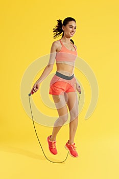 Fitness. Happy woman doing jumping exercises with skipping rope