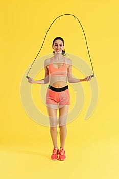 Fitness. Happy woman doing jumping exercises with skipping rope