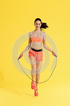 Fitness. Happy woman doing jumping exercises with skipping rope