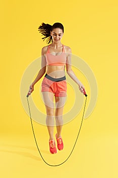 Fitness. Happy woman doing jumping exercises with skipping rope