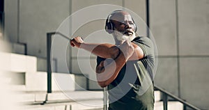 Fitness, headphones and senior black man stretching in city, workout and exercise for body health. Music, serious