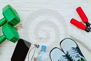 Fitness, healthy and active lifestyles Concept, Jump rope, dumbbells, sport shoes, bottle of water, smartphone with headphone