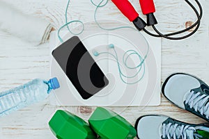 Fitness, healthy and active lifestyles Concept, Jump rope, dumbbells, sport shoes, bottle of water, smartphone with headphone