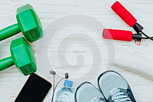 Fitness, healthy and active lifestyles Concept, Jump rope, dumbbells, sport shoes, bottle of water, smartphone with headphone