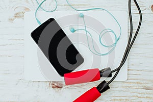 Fitness, healthy and active lifestyles Concept, Jump rope, dumbbells, sport shoes, bottle of water, smartphone with headphone