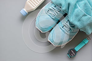 Fitness, healthy and active lifestyles Concept, sport shoes, smart watch, bottle of milk, towels on grey background. top view wit