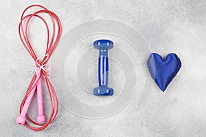 Fitness, healthy and active lifestyles love concept, dumbbells, jump rope, blue heart on blue background