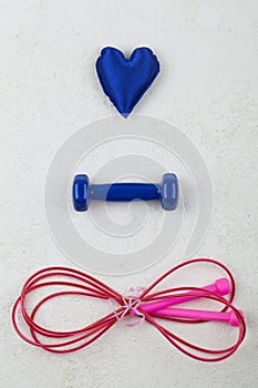 Fitness, healthy and active lifestyles love concept, dumbbells, jump rope, blue heart on white background