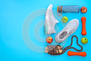 Fitness, healthy and active lifestyles love concept, dumbbells, sport shoes, bottle of waters, apples, and jump rope in heart