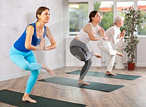 Fitness and healthy lifestyle concept: woman doing yoga yoga pose - vrikshasana pose on mat