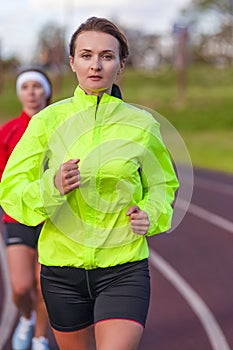 Fitness and Healthy Lifestyle Concepts. Two Female Athletes Having Running Exercises On Stadium
