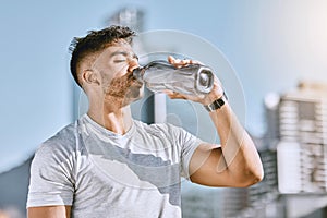 Fitness, healthy thirsty man drinking water while he is exercising outside in sportswear. Runner, cardio workout and