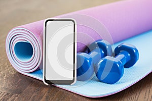 Fitness at home, smartphone app for online training, dumbbell weights and mat. Blank empty screen space, Set of workout inventory