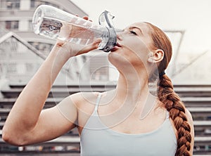 Fitness, hydration and a sports woman drinking water outdoor in the city during cardio or endurance exercise. Runner